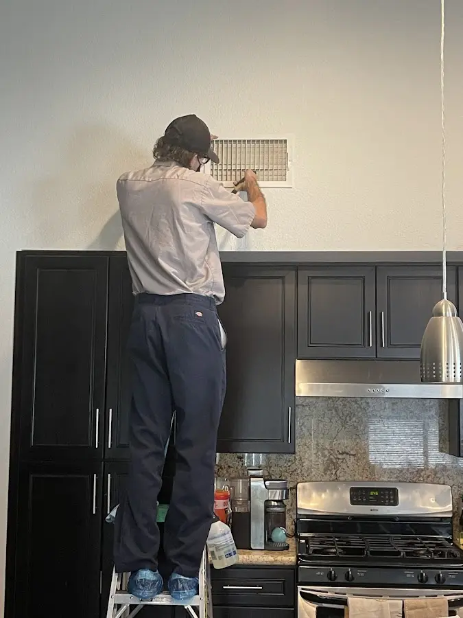 Technician inspecting an air vent during HVAC service in Bluffton